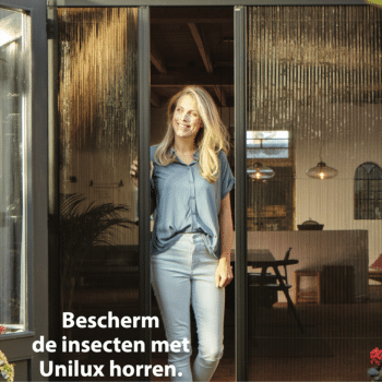 Op de foto is een vrouw te zien die in een deuropening staat met een open hordeur