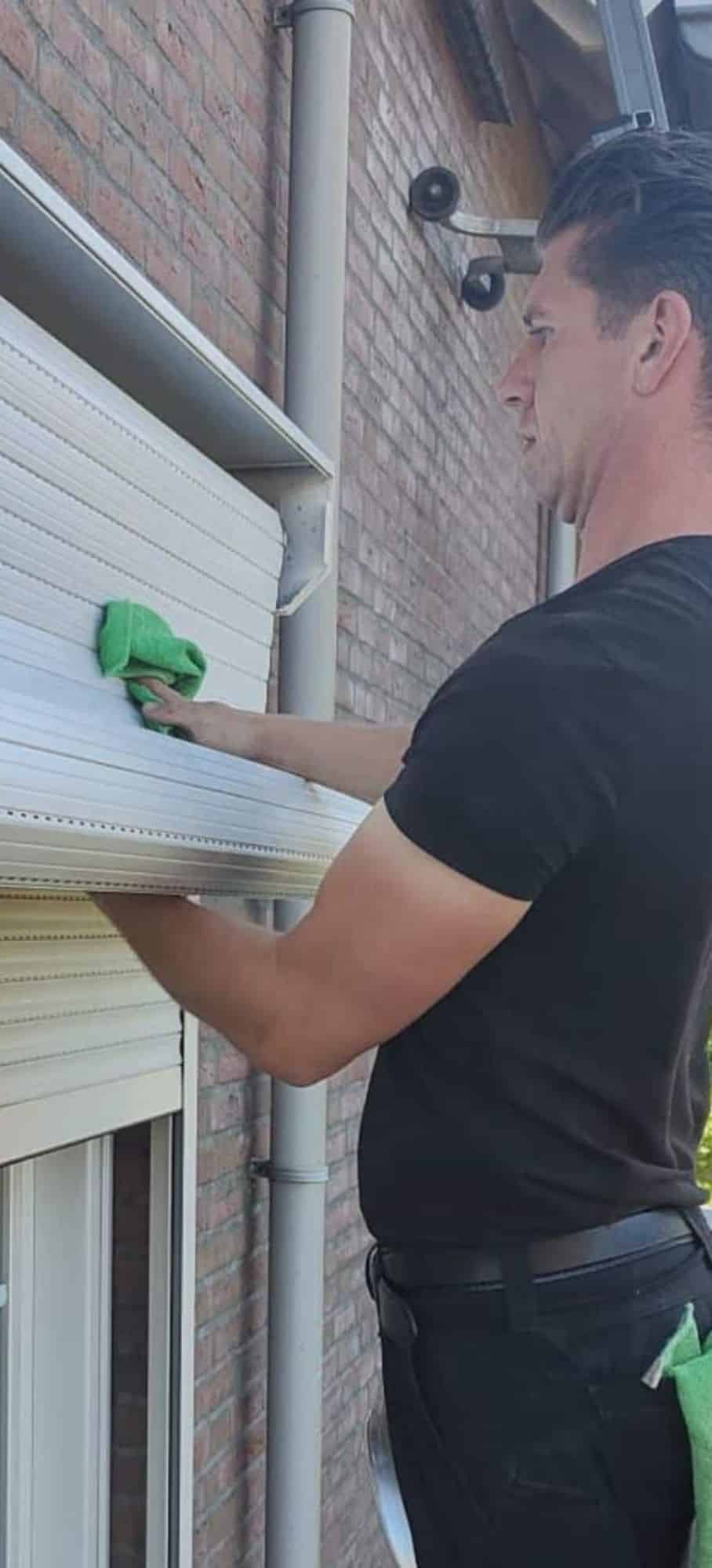 op deze foto is te zien hoe Paul van zonwering de boer een rolluik schoonmaakt aan de binnenkant