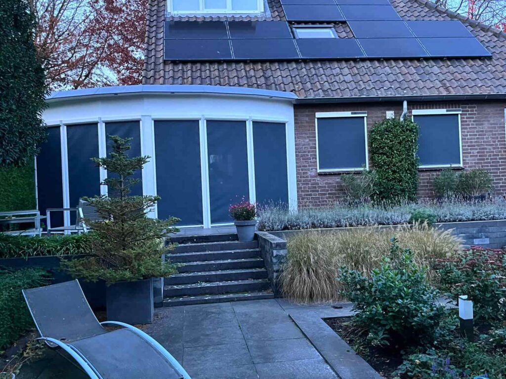 Op de foto is een erker te zien waarop screens zijn gemonteerd bij een huis in Horst